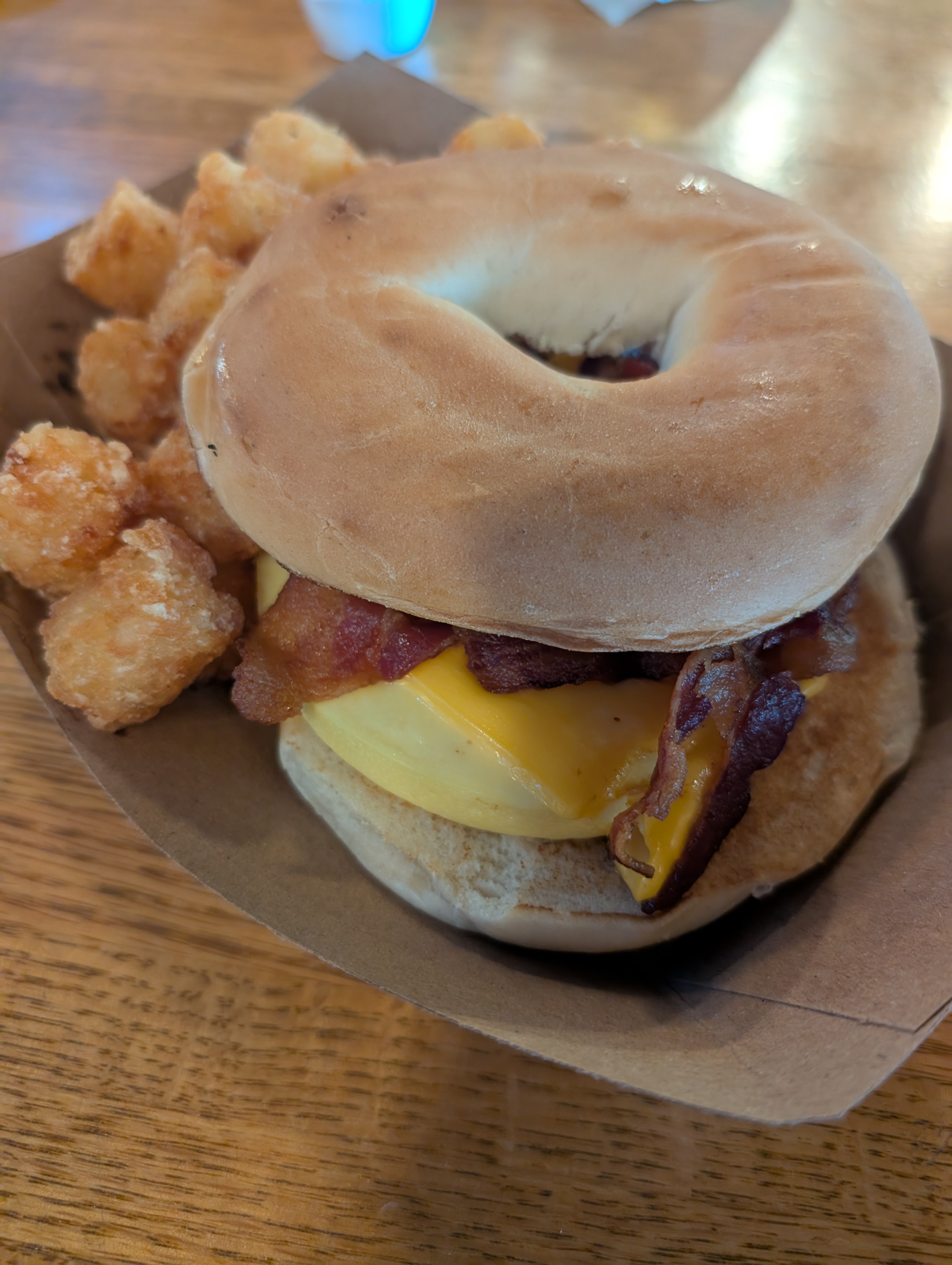 Bacon egg and cheese breakfast bagel with tots